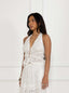 Woman wearing a broderie anglaise top against a white background